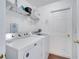 Functional laundry room with a modern washer and dryer and useful overhead shelving at 16608 Rising Star Dr, Clermont, FL 34714