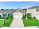 Tan house with white garage door, driveway and lawn, aerial view at 2321 Tay Wes Dr, Saint Cloud, FL 34771