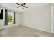 This bedroom boasts neutral carpet, a dark ceiling fan, and a window with curtains at 687 Irvine Ranch Rd, Kissimmee, FL 34759