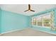 Bedroom with a ceiling fan, large window with blinds, and light turquoise walls at 687 Irvine Ranch Rd, Kissimmee, FL 34759