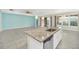 Spacious kitchen island featuring a sink and dishwasher overlooking the living area with sliding glass doors at 687 Irvine Ranch Rd, Kissimmee, FL 34759