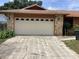 A closer look at the two-car garage, with decorative windows and stone pillars at 1414 Serissa Ct, Orlando, FL 32818