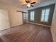 Spacious bedroom with wood-look floors, barn door, and plantation shutters at 3136 Porta Romano Way, Lake Mary, FL 32746