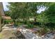 Well-maintained backyard with a stone pathway, lush greenery, and mature trees at 331 Douglas Dr, Eustis, FL 32726