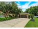 Exterior view of a charming single-story home, featuring a lush front yard and double-door garage at 331 Douglas Dr, Eustis, FL 32726