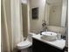 This bathroom is complete with a toilet, a sleek white sink, a decorative mirror, and shower with curtain at 9238 Kensington Row Ct, Orlando, FL 32827