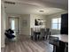 Bright dining room featuring modern light fixture and gray wood flooring at 9238 Kensington Row Ct, Orlando, FL 32827