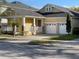 Charming home with two-car garage, covered porch, stone accents, and manicured lawn at 9238 Kensington Row Ct, Orlando, FL 32827