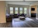 Bright living room featuring a seating arrangement and multiple windows, overlooking a landscaped yard at 9238 Kensington Row Ct, Orlando, FL 32827