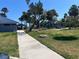 Lush park with mature palm trees, playground, and blue covered picnic area perfect for outdoor recreation and relaxation at 1801 James St, South Daytona, FL 32119