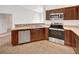 A functional kitchen featuring stainless steel appliances and wooden cabinetry at 1078 Osprey Cove Cir, Groveland, FL 34736