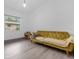 Cozy bedroom featuring modern mustard sofa, neutral walls, and wood-style flooring at 1521 Oxford Rd, Maitland, FL 32751