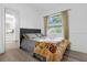 Cozy bedroom with a gray headboard, floral comforter, wood-look floors, and window with curtains at 1521 Oxford Rd, Maitland, FL 32751