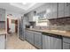 Bright kitchen featuring gray cabinets, tiled backsplash, and stainless steel appliances with eat in area at 1521 Oxford Rd, Maitland, FL 32751