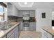 Well-lit kitchen featuring stainless steel appliances, tile backsplash, and modern grey cabinetry at 1521 Oxford Rd, Maitland, FL 32751