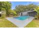 Inviting pool features a stainless steel ladder and a cool deck, surrounded by a garden and mature trees at 1521 Oxford Rd, Maitland, FL 32751