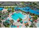 Aerial view of the expansive blue-roofed community pool with beach umbrellas and lounge chairs at 1697 Kona Ln, Davenport, FL 33897