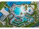 Stunning aerial view of the community pool and lazy river with colorful umbrellas and lush landscaping at 1697 Kona Ln, Davenport, FL 33897