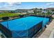 Bright blue outdoor basketball court surrounded by fencing and lush green grass at 1697 Kona Ln, Davenport, FL 33897