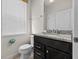 Cozy bathroom featuring granite counters, white cabinets and a window for natural light at 1697 Kona Ln, Davenport, FL 33897