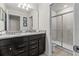 Bathroom featuring dual sinks with granite counters, dark wood cabinets and a glass enclosed shower at 1697 Kona Ln, Davenport, FL 33897