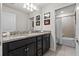 Bathroom with dual sinks, dark wood cabinets and a shower/bath at 1697 Kona Ln, Davenport, FL 33897