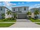 Inviting two-story home with a well-maintained lawn, palm trees, and a brick-paved driveway at 1697 Kona Ln, Davenport, FL 33897