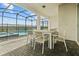 Covered patio featuring an outdoor dining set and peaceful pool views at 1697 Kona Ln, Davenport, FL 33897