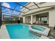 Backyard pool and spa area under a screened in enclosure with an outdoor dining area at 1697 Kona Ln, Davenport, FL 33897