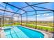 Inviting screened pool and spa overlooking the beautiful landscaping and community at 1697 Kona Ln, Davenport, FL 33897