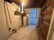 Utility area with water heater, tiled floor, shelving, and access to another room at 1951 S Crystal Lake Dr, Orlando, FL 32806