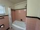 Bathroom with pink tile, black trim, and a shower/tub with a patterned shower curtain at 1951 S Crystal Lake Dr, Orlando, FL 32806