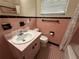Pink bathroom with tile floors, single sink vanity, and a shower/tub with patterned shower curtain at 1951 S Crystal Lake Dr, Orlando, FL 32806