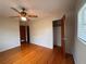 Bedroom features hardwood floors, ceiling fan, closet, and a large window for natural light at 1951 S Crystal Lake Dr, Orlando, FL 32806