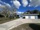 Charming home featuring a well-maintained lawn, a three-car garage, and a flowering tree in the front yard at 1951 S Crystal Lake Dr, Orlando, FL 32806