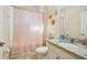 Bathroom with tub shower, granite countertop vanity, and pink shower curtain at 310 Villa Sorrento Cir, Haines City, FL 33844