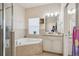 Bathroom with corner tub, shower, and granite vanity at 310 Villa Sorrento Cir, Haines City, FL 33844