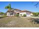 Front view of a single story home with a tile roof and palm trees at 310 Villa Sorrento Cir, Haines City, FL 33844