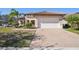Single-story home with tile roof, paver driveway, and landscaped yard at 310 Villa Sorrento Cir, Haines City, FL 33844