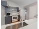 Kitchen featuring a stainless steel sink, grey cabinets, white appliances, and light countertops at 409 Horizon Dr, Winter Springs, FL 32708