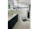 Modern bathroom with walk-in shower, dark vanity, and hexagon tile at 737 Trillium Ct, Debary, FL 32713