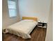 Cozy bedroom featuring a comfortable bed, natural light from a window, and wood flooring at 737 Trillium Ct, Debary, FL 32713
