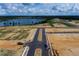 Aerial view of new construction with a lake, roads, and construction equipment at 16875 Muskgrass Dr, Winter Garden, FL 34787