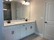 Bathroom featuring double sink vanity, quartz countertops, modern fixtures, and framed mirror at 16875 Muskgrass Dr, Winter Garden, FL 34787