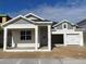 Craftsman style home with gray siding, white trim, and a two-car garage at 16875 Muskgrass Dr, Winter Garden, FL 34787