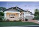 Two-story home with stone accents, light beige siding, and a two-car garage at 16875 Muskgrass Dr, Winter Garden, FL 34787