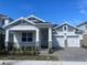 Charming new construction home featuring a welcoming front porch, brick driveway, and two-car garage at 16875 Muskgrass Dr, Winter Garden, FL 34787