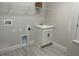 Laundry room with utility sink, overhead storage, and washer/dryer hookups at 16875 Muskgrass Dr, Winter Garden, FL 34787