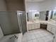 Bright white main bathroom with double vanity, walk-in shower, soaking tub, and lots of mirror lighting at 284 Pinestraw Cir, Altamonte Springs, FL 32714