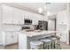 Modern kitchen features white cabinets, quartz countertops, stainless steel appliances, and a center island with bar seating at 1302 Belmar Ter, Deltona, FL 32725